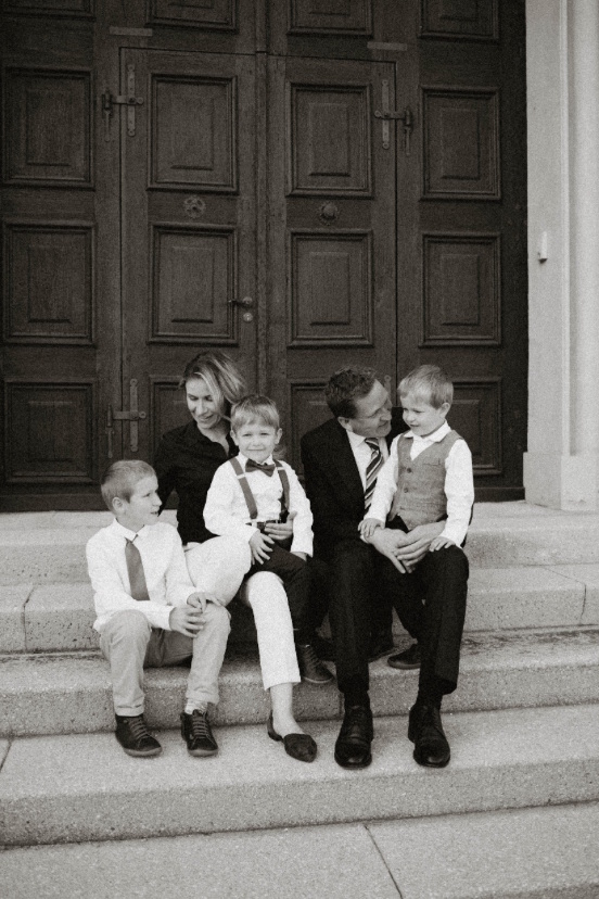 Olga Zimmermann mit ihrer Familie auf einer Treppe sitzend vor einem großen Holztor