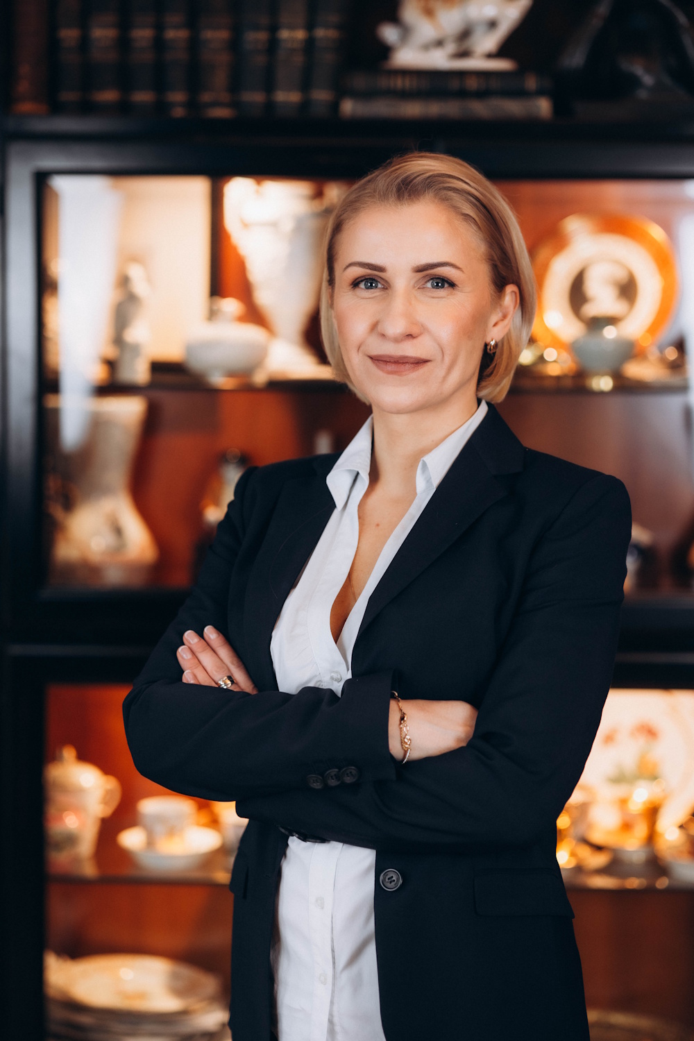 Olga Zimmermann stehend mit verschränkten Händen im dunklen Blazer und hellen Hemd